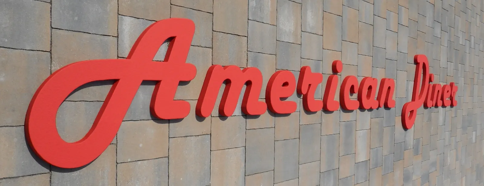 Crveni 3D natpis American Diner postavljen na zidnu oblogu